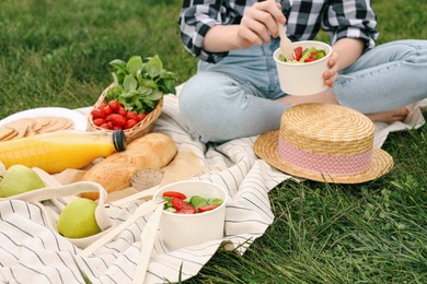 Photo of Girl having picnic on green grass in park, closeup