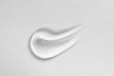 Smear of cosmetic oil on white background, top view