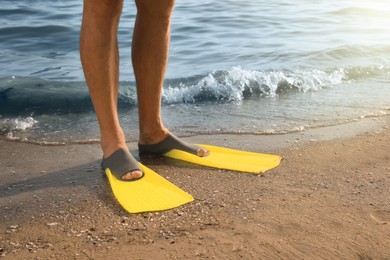 Photo of Man in flippers on sandy beach, closeup