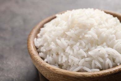 Photo of Bowl of tasty cooked white rice on table, closeup