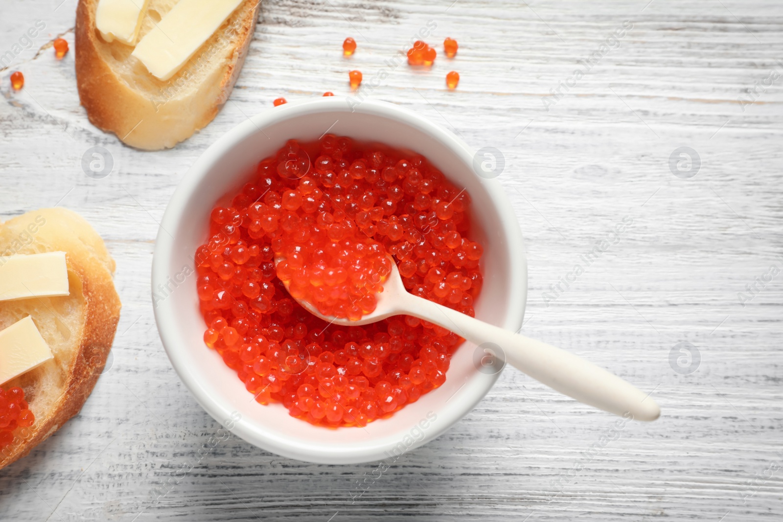 Photo of Flat lay composition with red caviar on wooden background