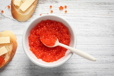 Photo of Flat lay composition with red caviar on wooden background