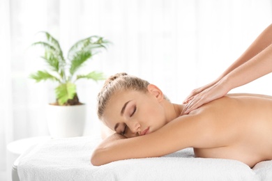 Photo of Relaxed woman receiving back massage in wellness center