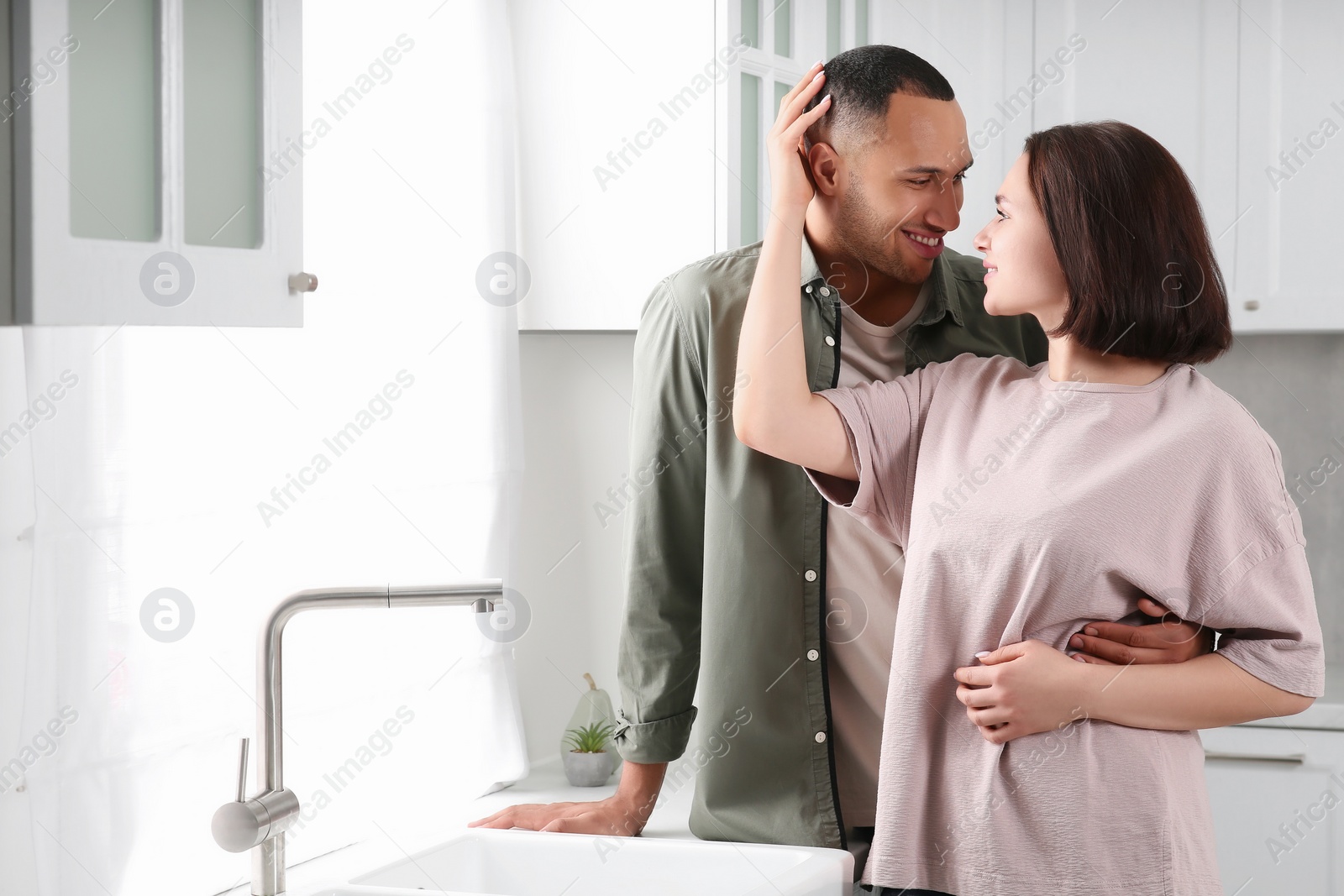 Photo of Dating agency. Happy couple spending time together in kitchen, space for text