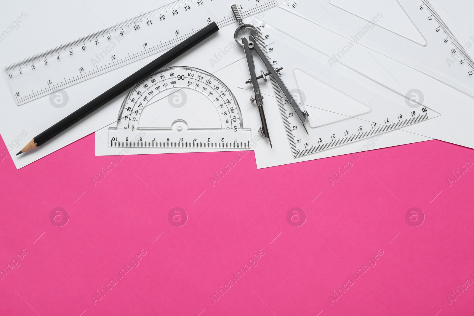 Photo of Different rulers, pencil and compass on pink background, flat lay. Space for text