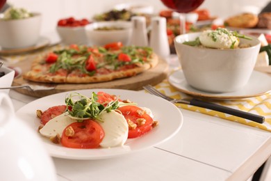 Photo of Mozzarella, fresh tomatoes and basil served on buffet table for brunch