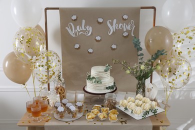 Photo of Beautiful cake and other treats on table in room. Baby shower party