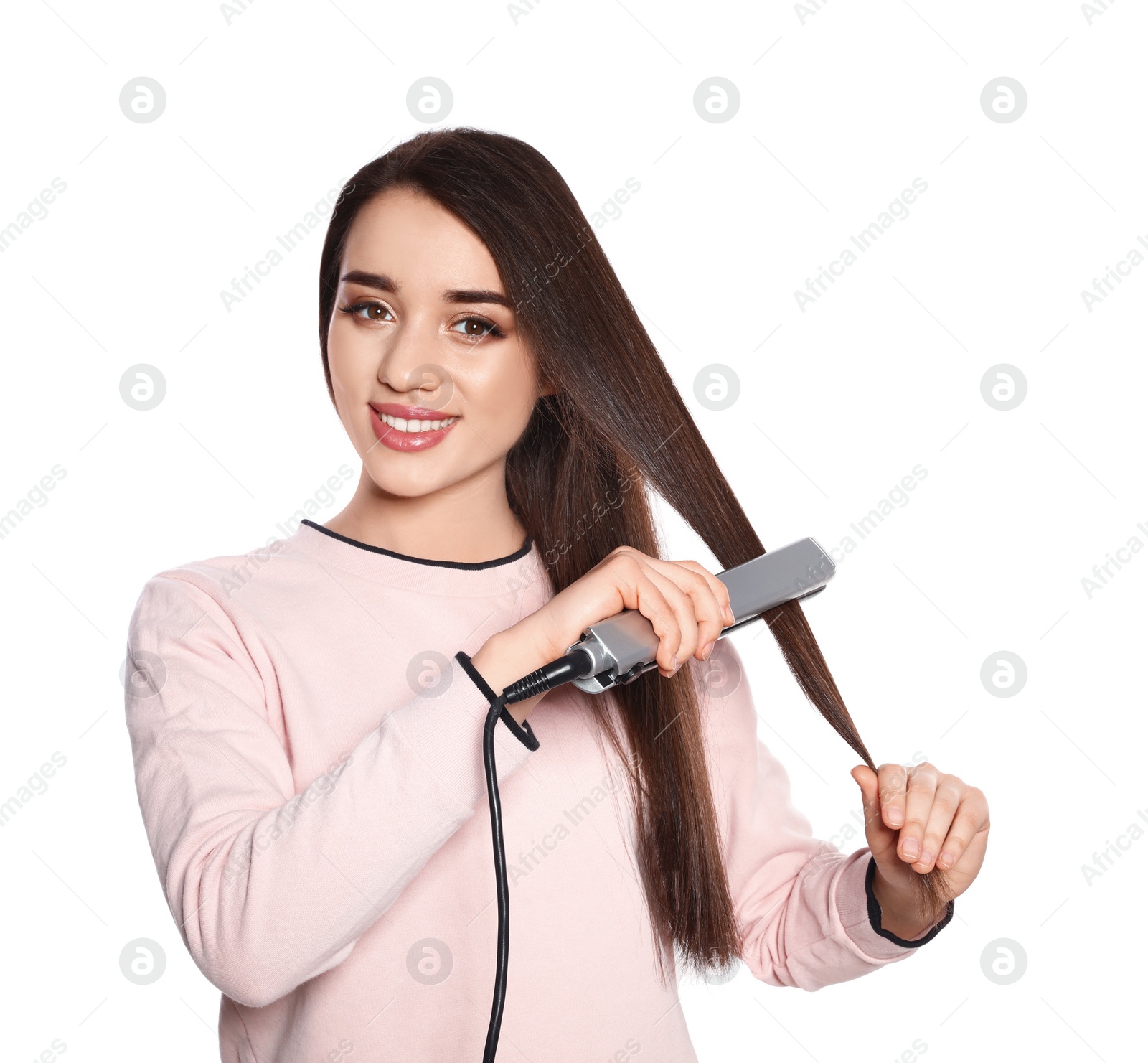 Photo of Happy woman using hair iron on white background