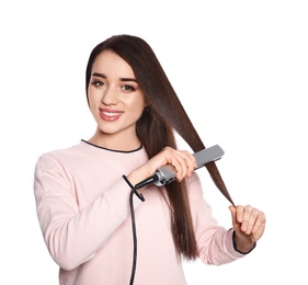 Happy woman using hair iron on white background