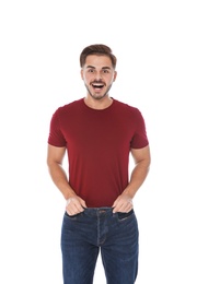 Fit man in oversized jeans on white background. Weight loss