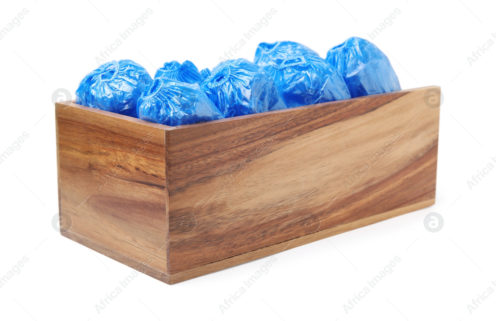 Photo of Rolled blue shoe covers in wooden crate isolated on white