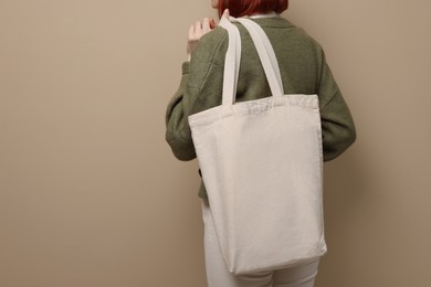 Woman with eco bag on beige background, closeup. Space for text