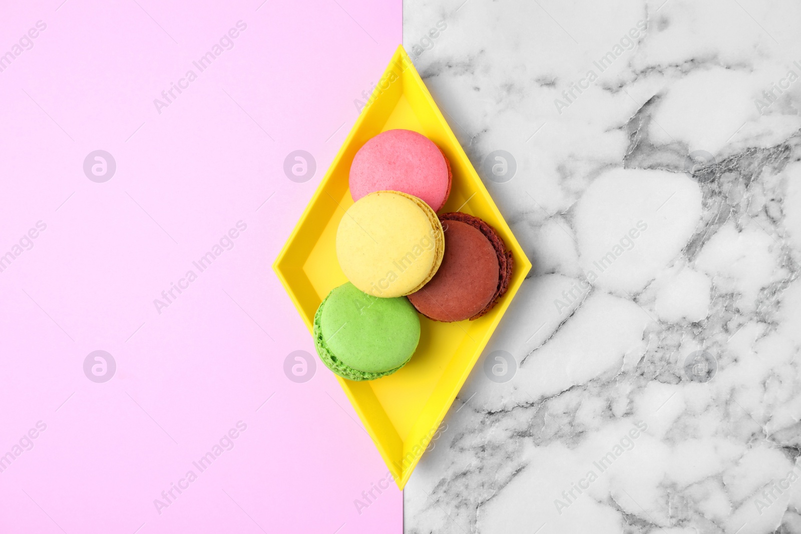 Photo of Tray with tasty fresh macaroons on color background, top view. Space for text