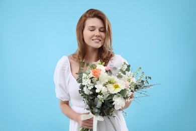 Photo of Beautiful woman with bouquet of flowers on light blue background