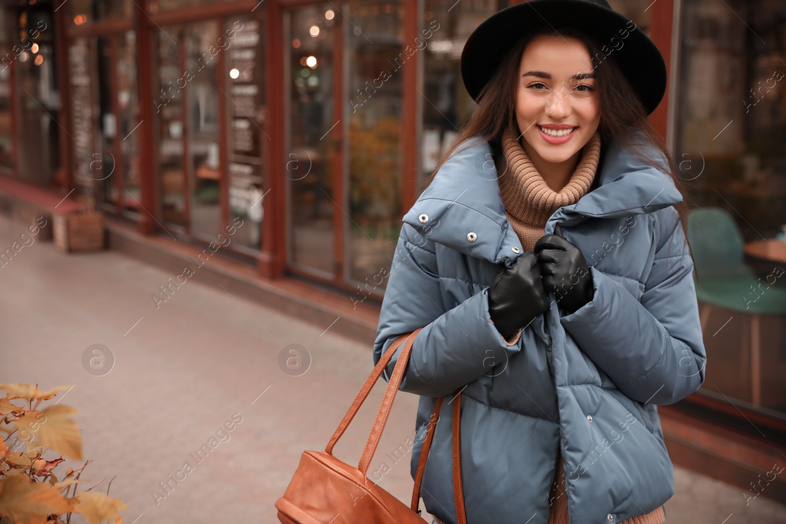 Photo of Young woman wearing stylish clothes on city street, space for text. Autumn look