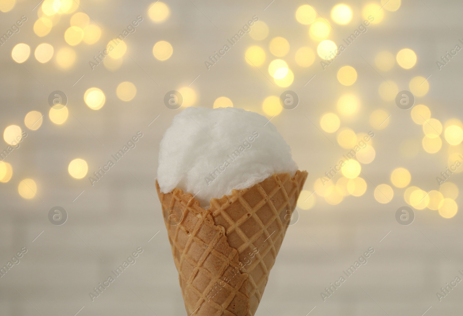 Photo of Cotton candy in waffle cone against blurred lights, closeup