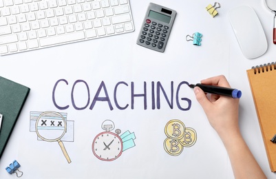 Woman writing word "Coaching" on white background. Business trainer concept
