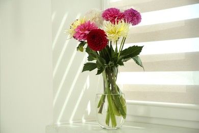 Photo of Bouquet of beautiful Dahlia flowers in vase on windowsill indoors
