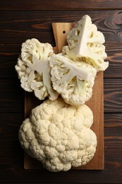 Photo of Fresh raw cauliflower on wooden table, top view