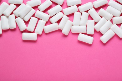 Photo of Tasty white chewing gums on pink background, flat lay. Space for text