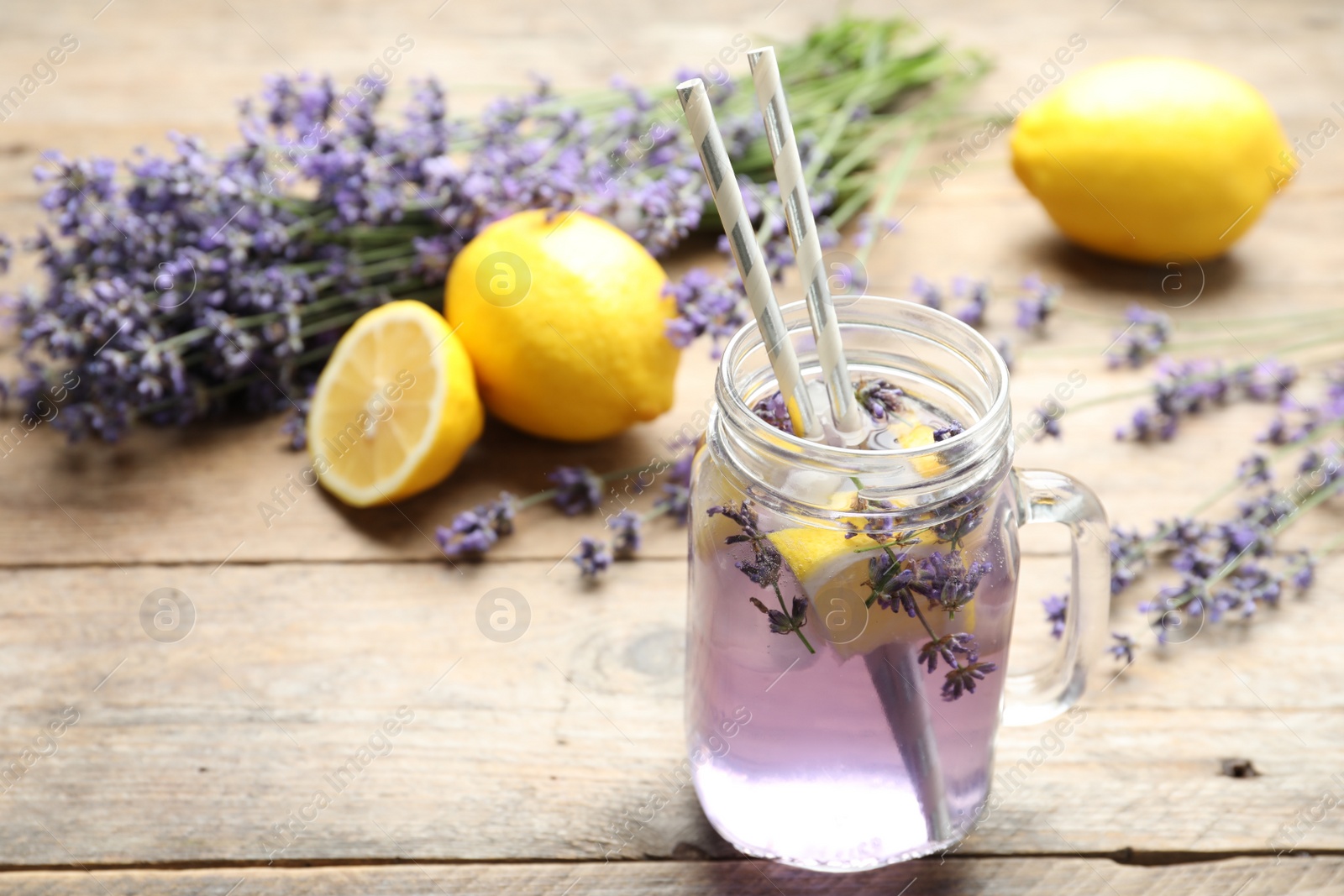 Photo of Fresh delicious lemonade with lavender in masson jar on wooden table. Space for text