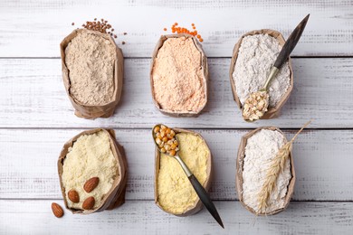 Photo of Flat lay composition with different types of flour on white wooden table