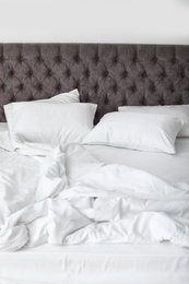 Photo of Soft white pillows on comfortable bed, closeup