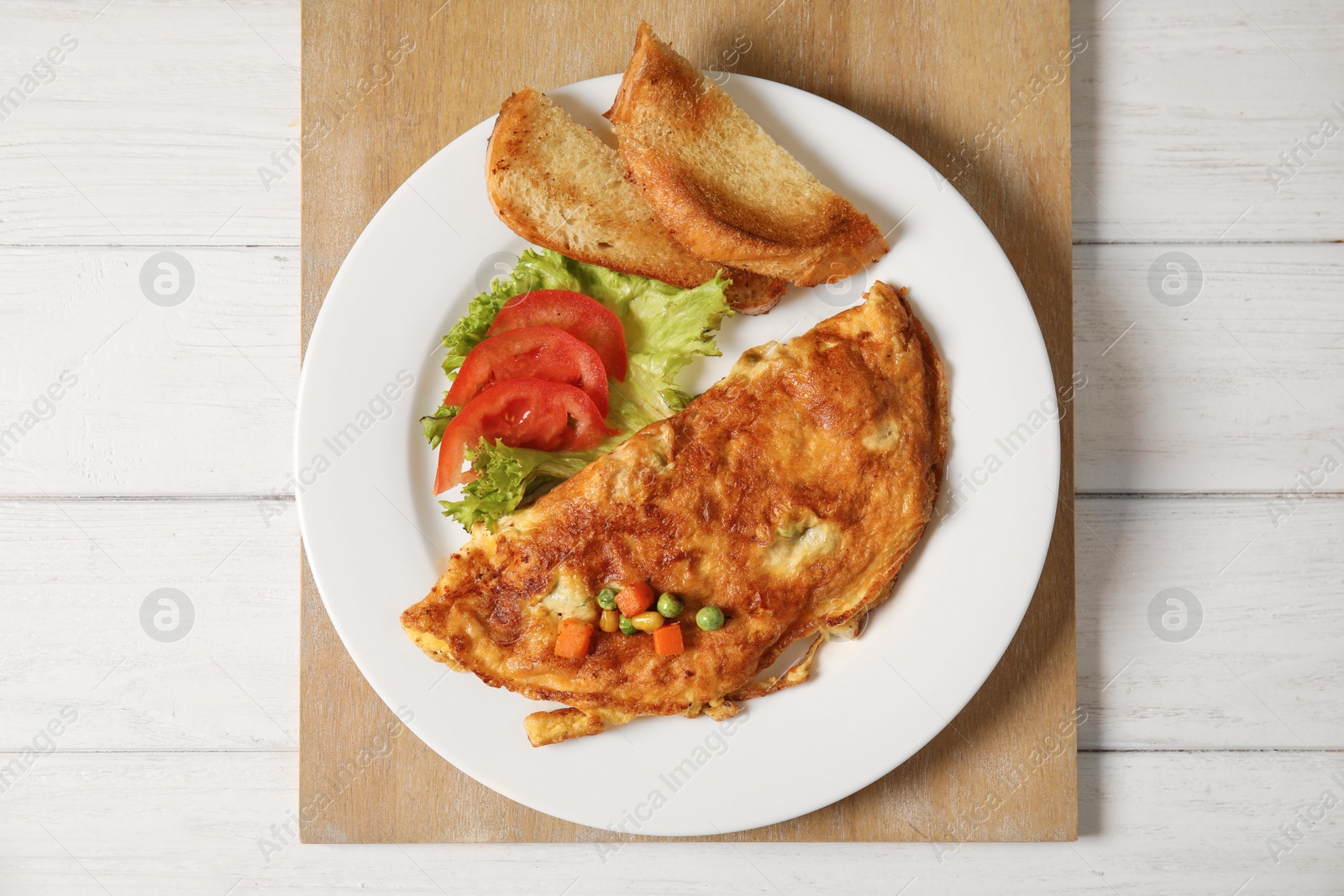 Photo of Omelet with vegetables on plate served for breakfast, top view