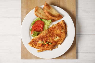 Omelet with vegetables on plate served for breakfast, top view