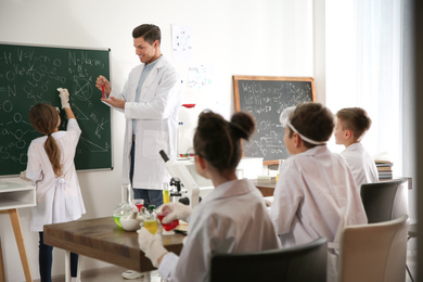 Photo of Teacher with pupils at chemistry lesson in classroom