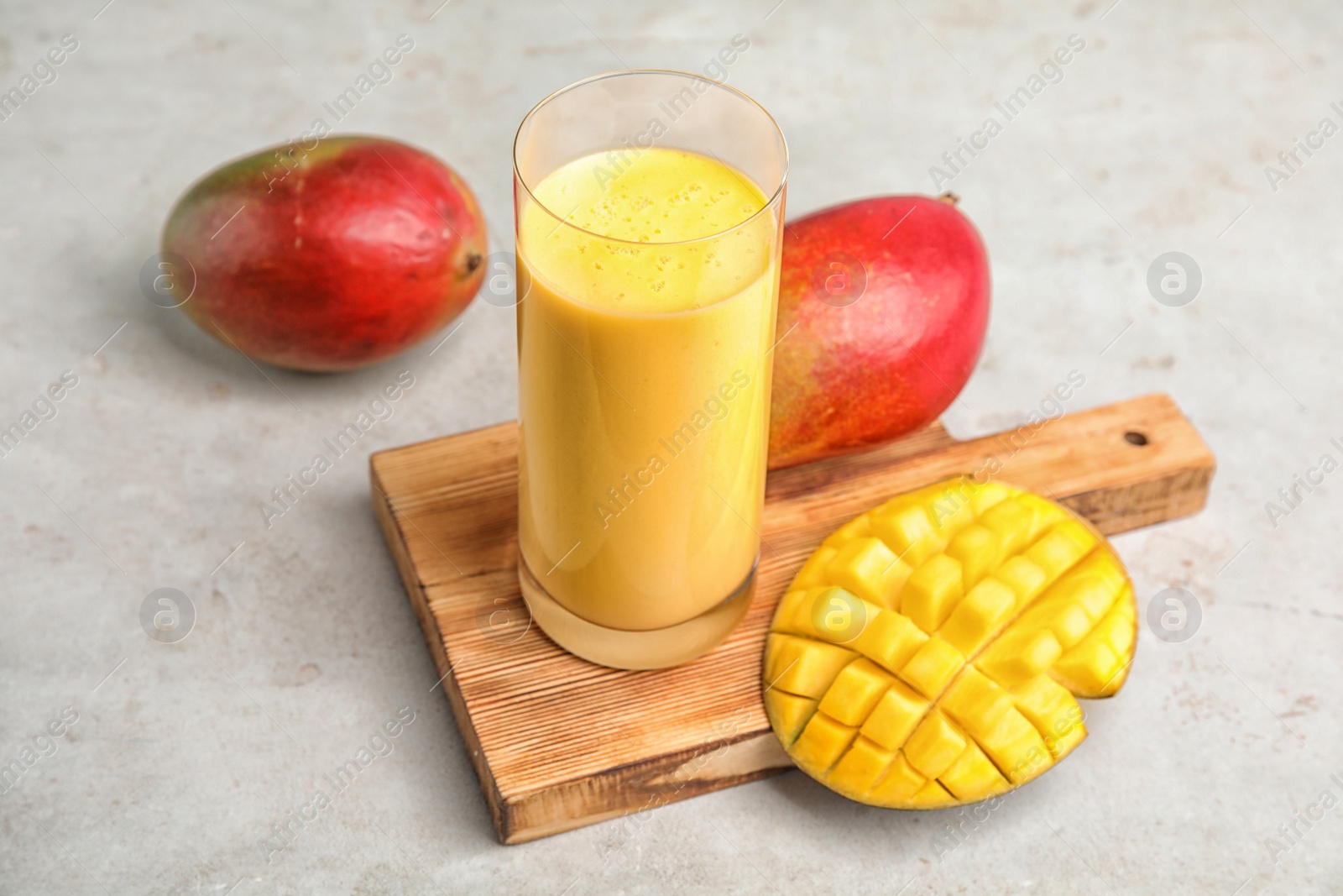 Photo of Glass of fresh mango drink and fruits on table