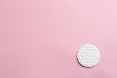 Cotton pad on color background, top view. Space for text