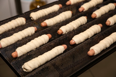 Unbaked sausage rolls on tray in workshop