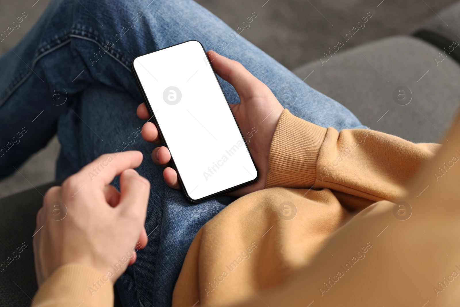 Photo of Man using smartphone with blank screen indoors, closeup. Mockup for design