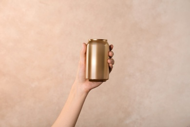 Photo of Woman holding aluminum can on light background