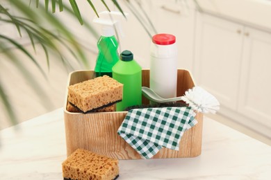 Photo of Different cleaning supplies on table in kitchen
