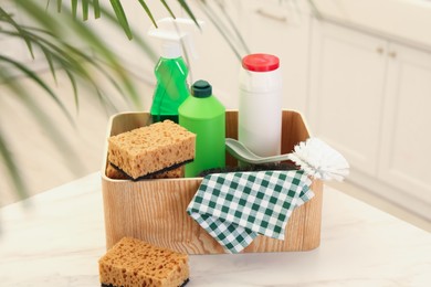 Different cleaning supplies on table in kitchen