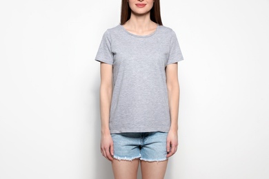 Young woman in t-shirt on light background, closeup. Mock up for design