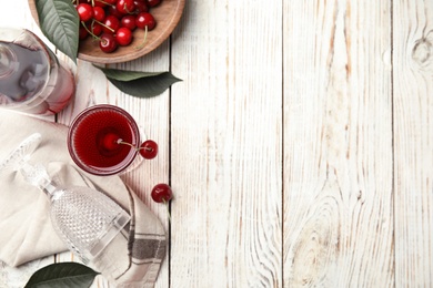 Photo of Delicious cherry wine with ripe juicy berries on white wooden table, flat lay. Space for text