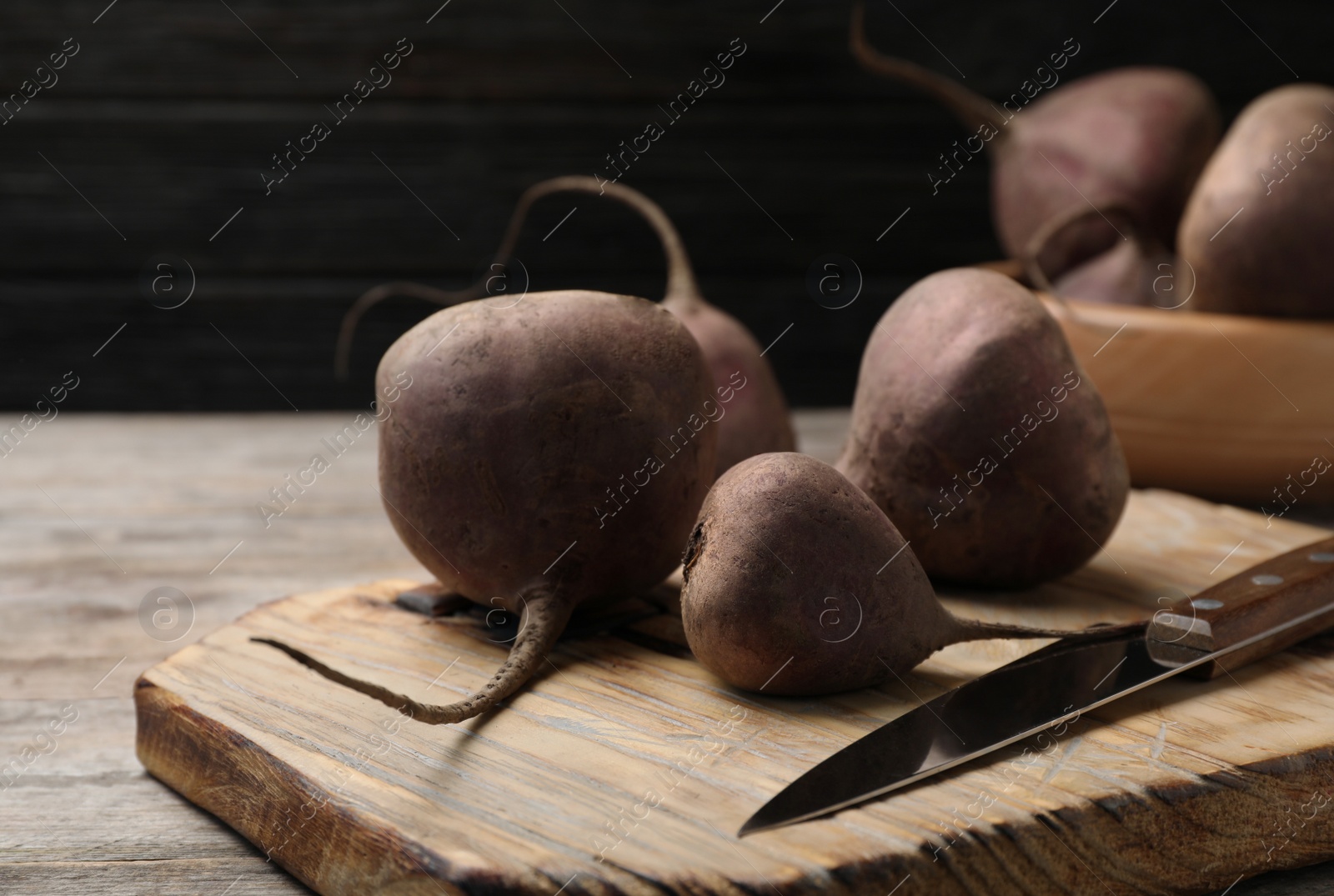 Photo of Wooden board with ripe beets on table