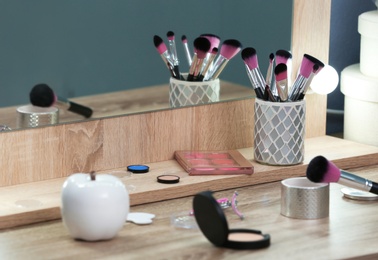 Decorative cosmetics and tools on dressing table in makeup room