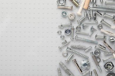 Photo of Many different fasteners on plastic surface, flat lay. Space for text