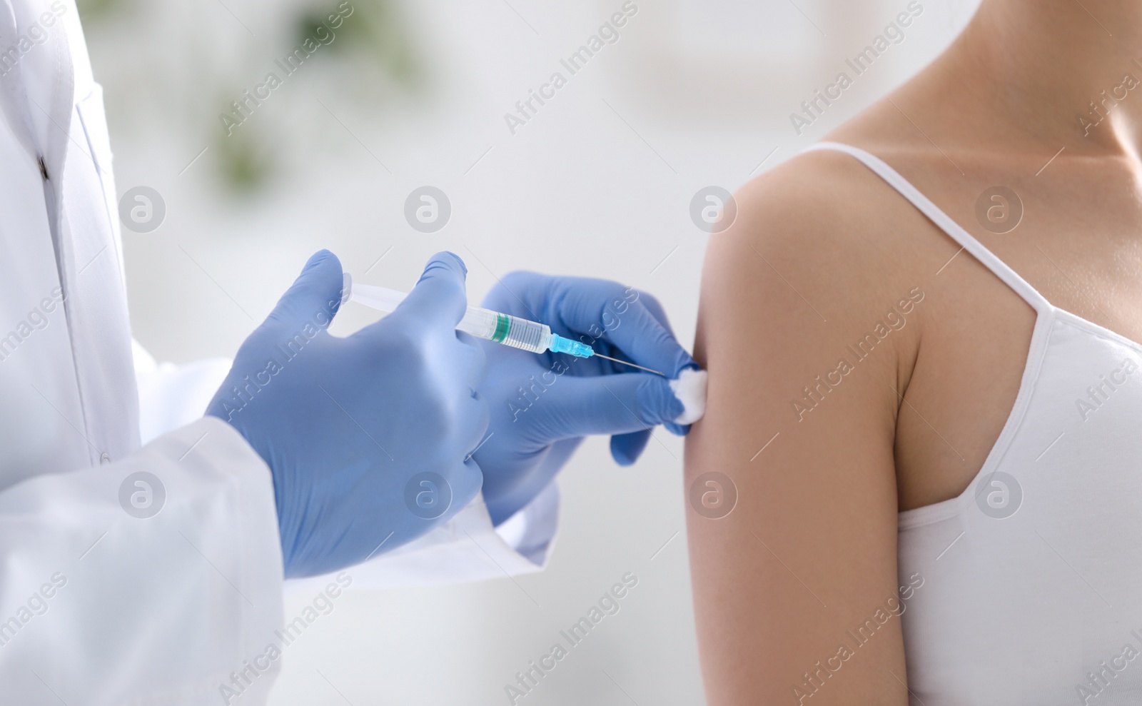 Photo of Doctor giving injection to patient in hospital, closeup. Vaccination concept