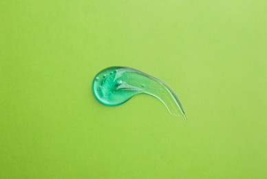 Photo of Smear of ointment on light green background, top view