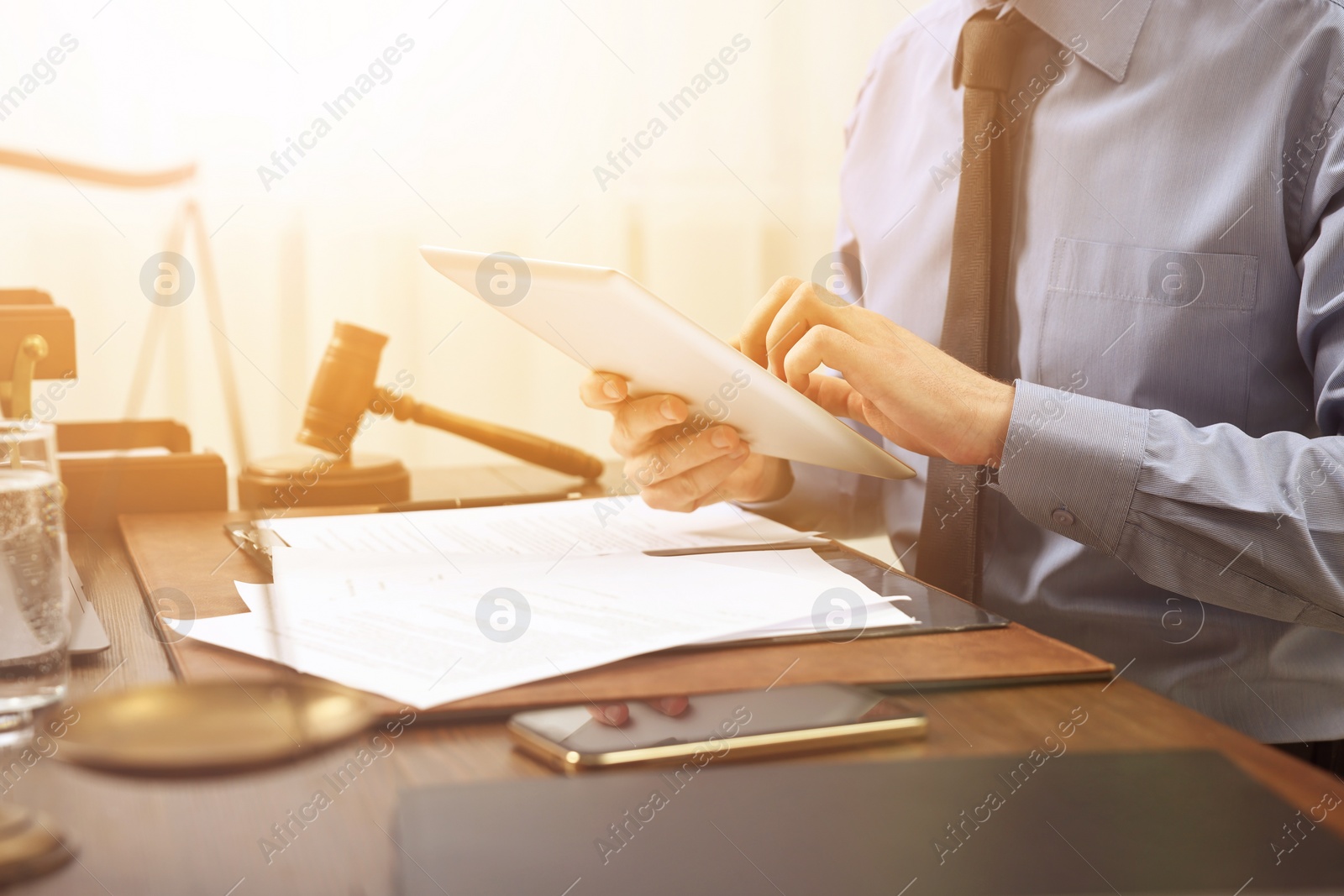 Image of Lawyer using tablet at wooden table, closeup