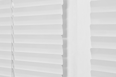 Photo of Window with closed modern horizontal blinds indoors, closeup