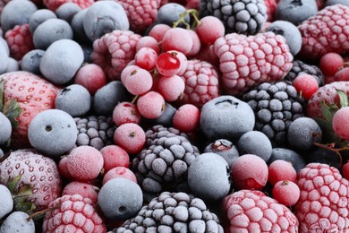 Photo of Mix of different frozen tasty berries as background, closeup