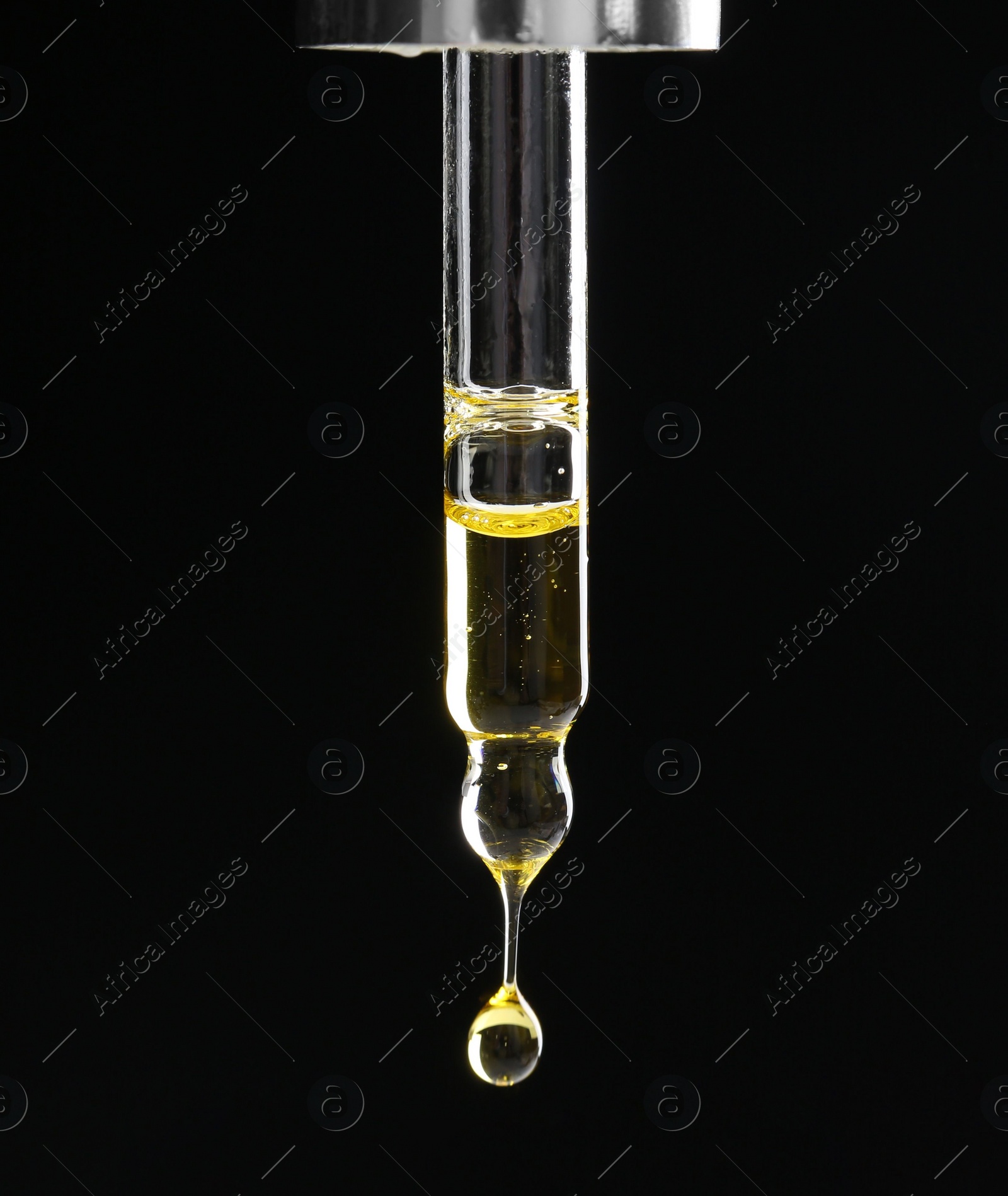 Photo of Dripping tincture from pipette on black background, closeup