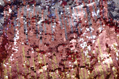 Photo of Texture of stylish pink carnival dress with sequins as background, top view