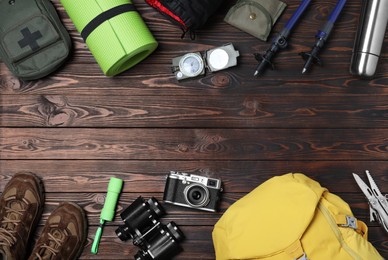 Photo of Flat lay composition with tourist backpack and camping equipment on wooden background, space for text